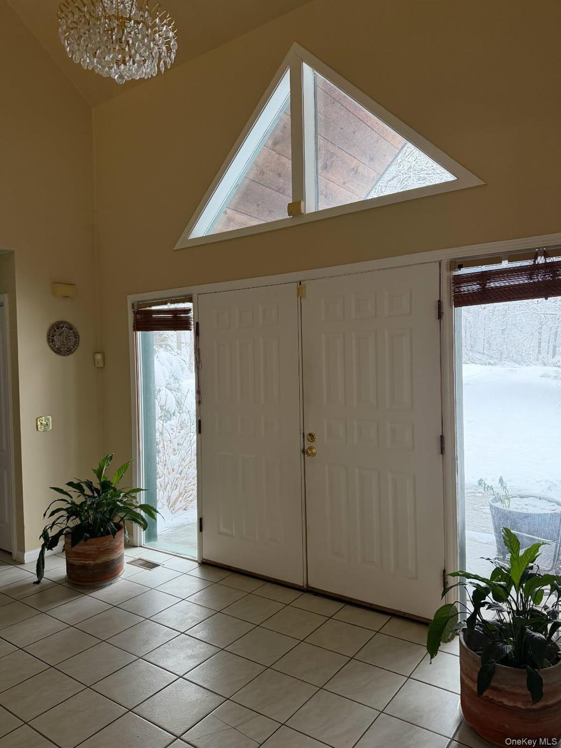 4 Greenlawn Road Cortlandt Manor, NY 10567 - Photo 6 of 24 Entrance foyer with high vaulted ceiling, light tile patterned floors, and a chandelier