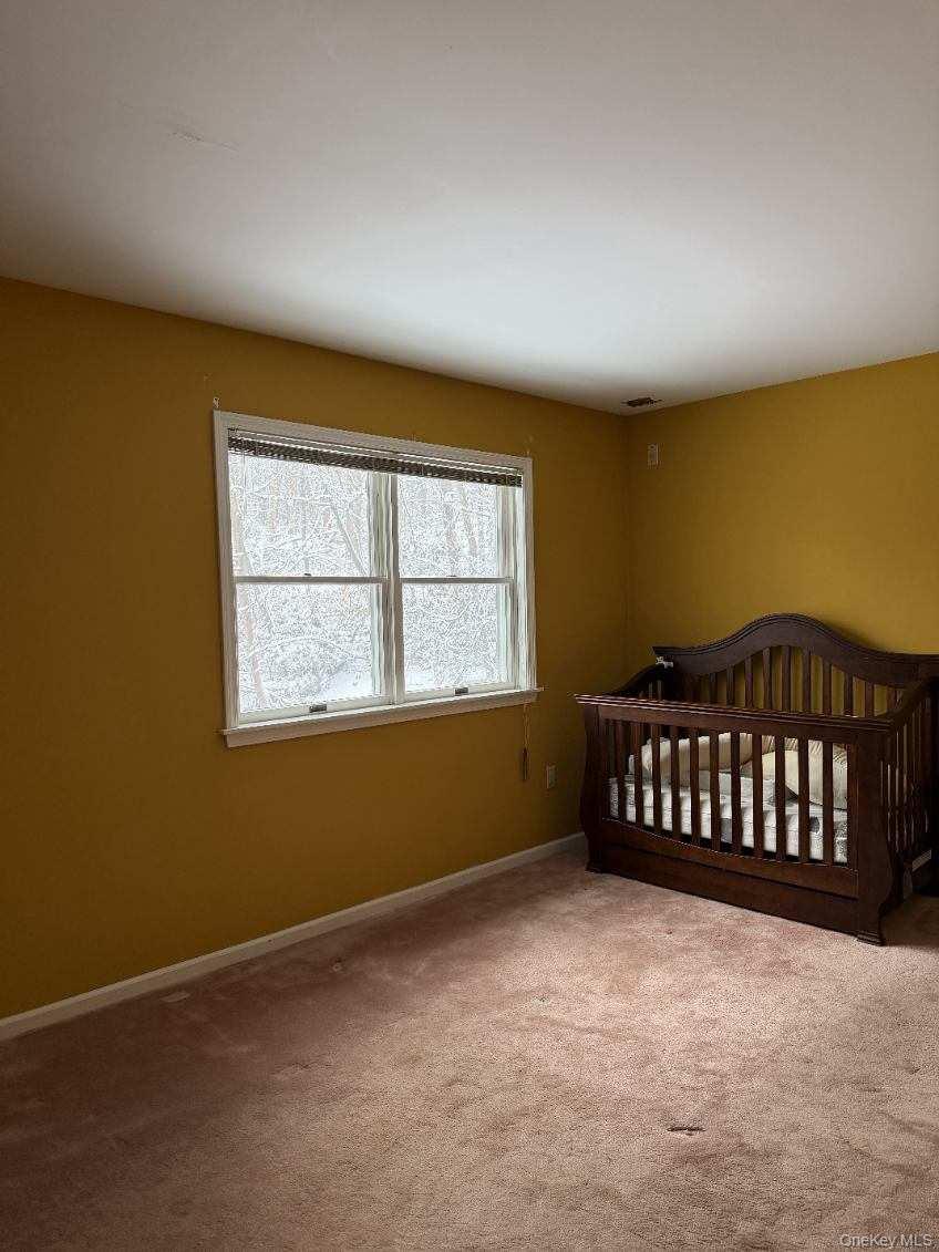 4 Greenlawn Road Cortlandt Manor, NY 10567 - Photo 8 of 24 Unfurnished bedroom with a crib and carpet