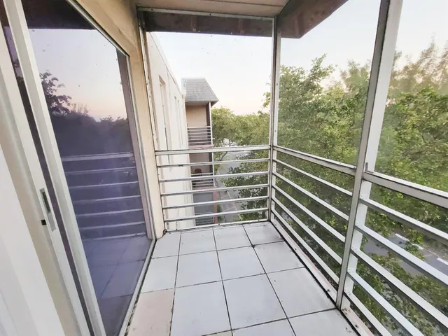 a view of empty room with wooden floor and window