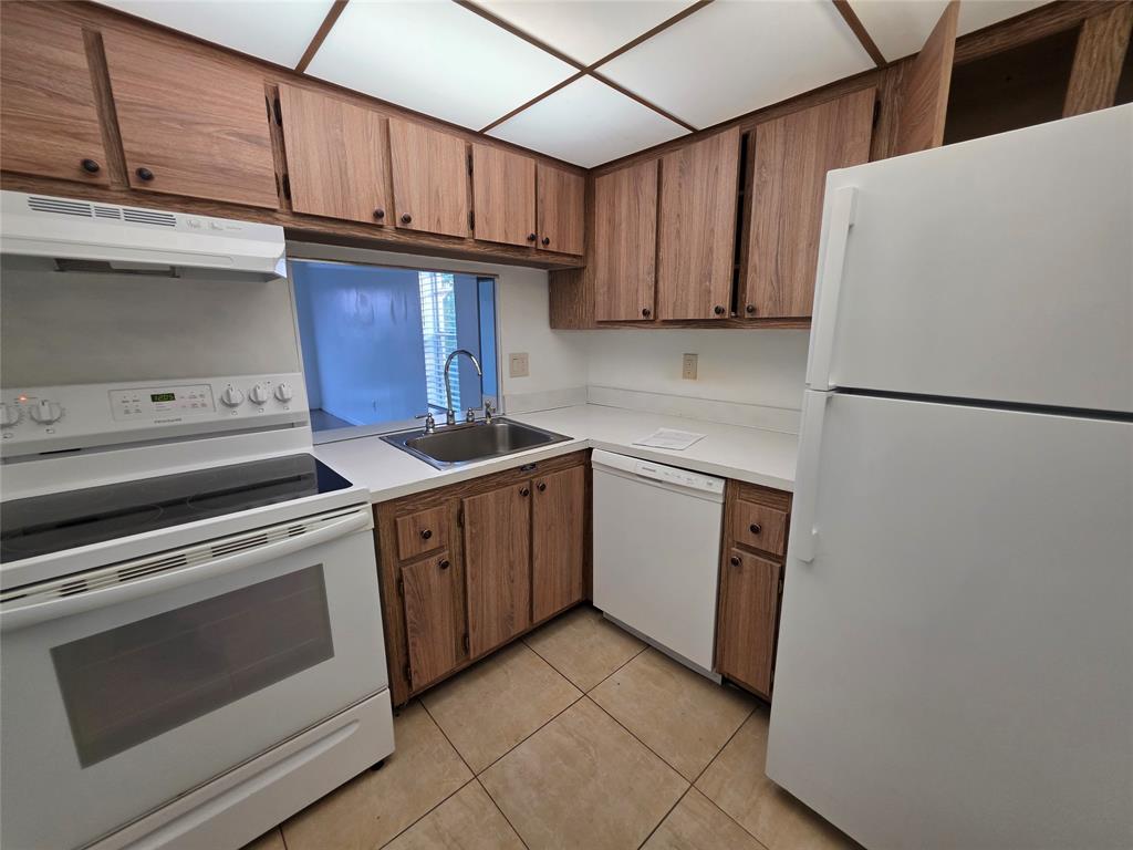 2800 Northwest 56th Avenue, Unit E407 Lauderhill, FL 33313 - Photo 4 of 15 a kitchen with a stove cabinets and a refrigerator