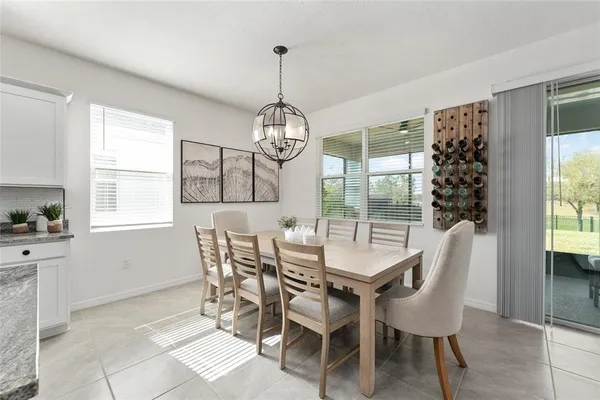 a kitchen with stainless steel appliances kitchen island granite countertop a table chairs and a refrigerator