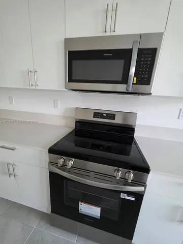 a stove top oven sitting inside of a kitchen