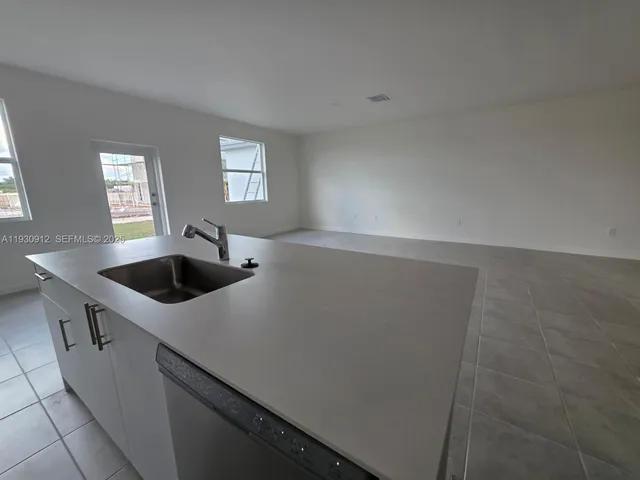 a kitchen with a sink a refrigerator and window