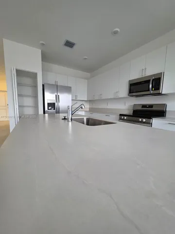 a kitchen with stainless steel appliances a sink a stove and cabinets