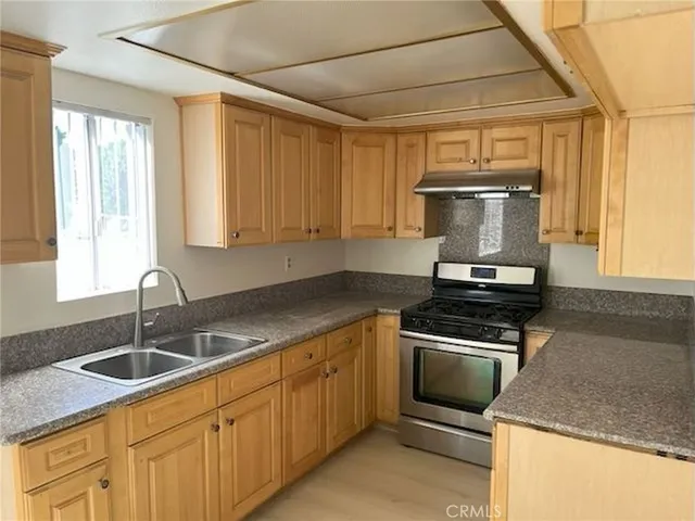 a kitchen with a sink stove and cabinets
