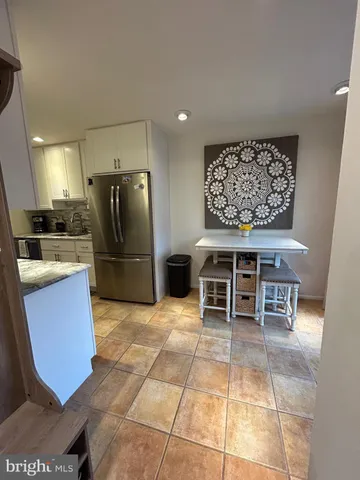 a kitchen with stainless steel appliances kitchen island granite countertop a refrigerator and a stove