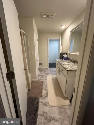 a bathroom with sink a mirror a washer and dryer