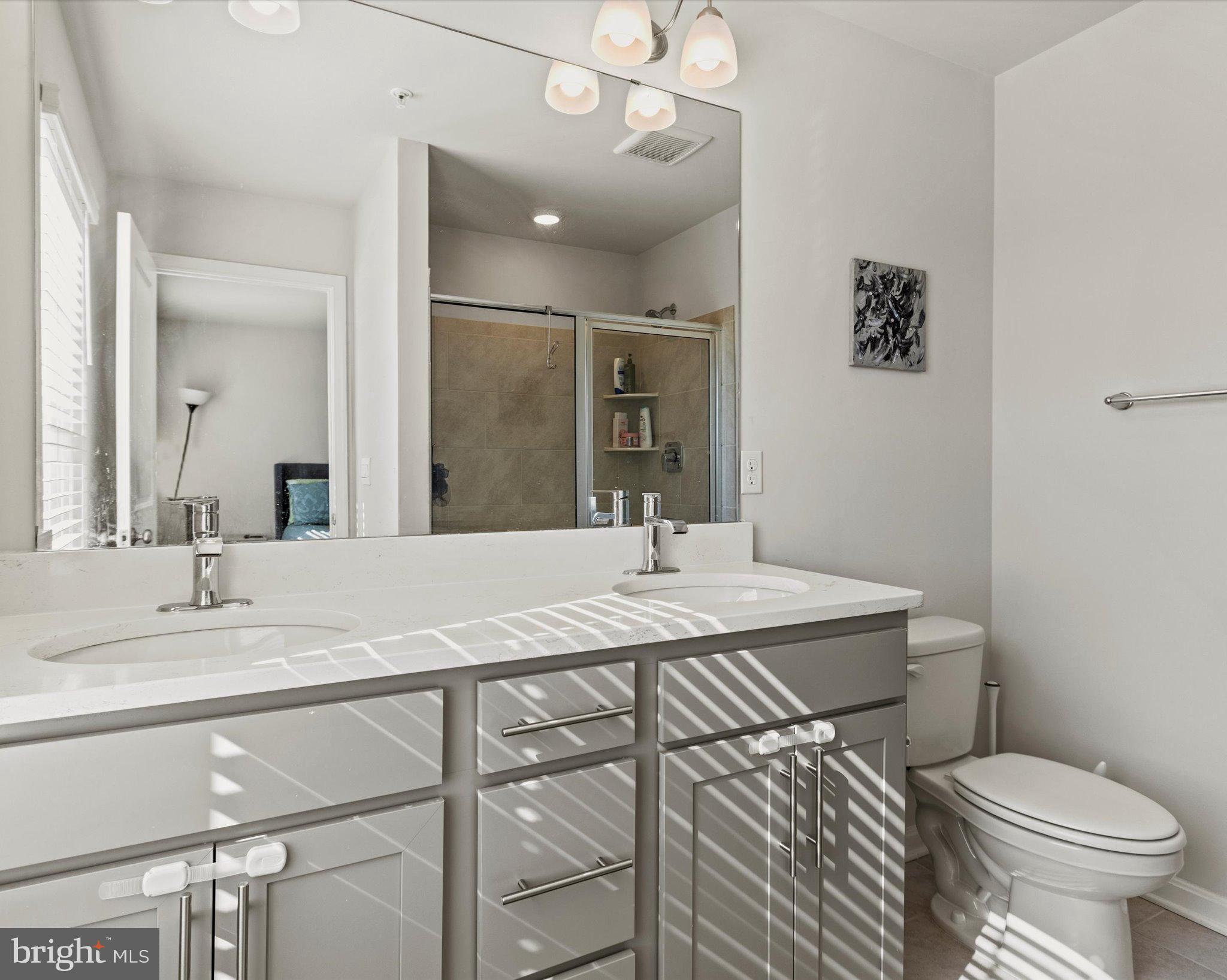 6610 Bullrush Court Clinton, MD 20735 - Photo 12 of 22 a bathroom with a granite countertop sink a toilet and a mirror