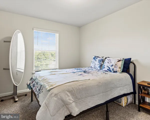 a bed sitting in a bedroom next to a window