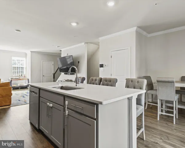 a kitchen with a sink and chairs