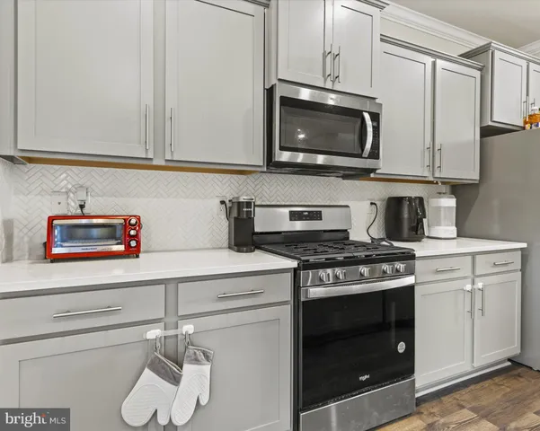 a kitchen with stainless steel appliances a stove a microwave and cabinets