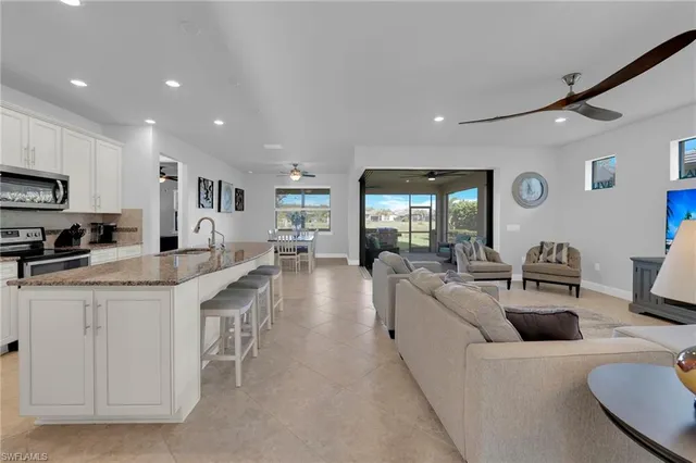 a large white kitchen with lots of counter space dining table and chairs