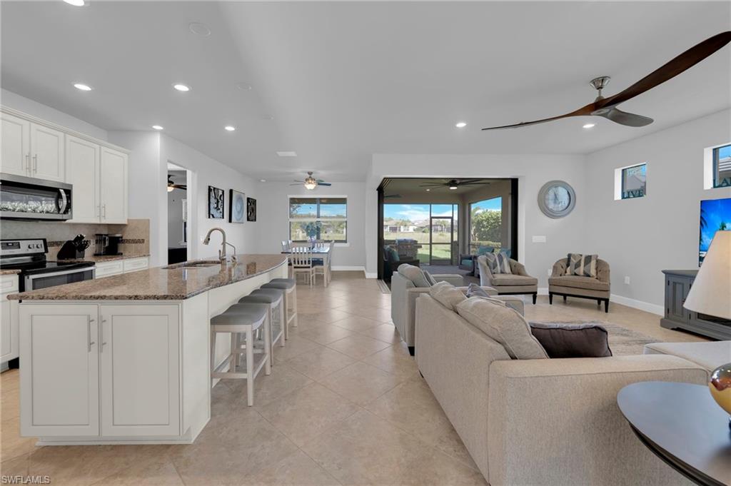 a large white kitchen with lots of counter space dining table and chairs