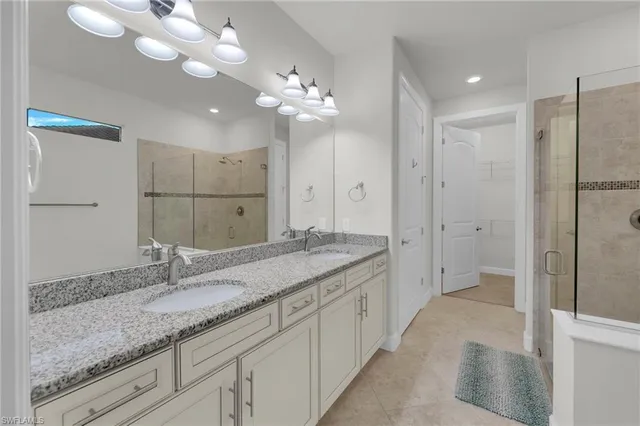 a bathroom with a granite countertop sink a large mirror and a shower