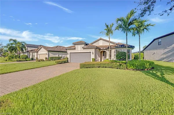 a front view of a house with a garden and yard