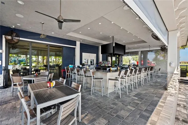 a view of a dining hall with lots of tables a large window and couches