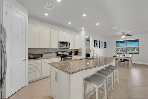 a kitchen with granite countertop white cabinets and stainless steel appliances