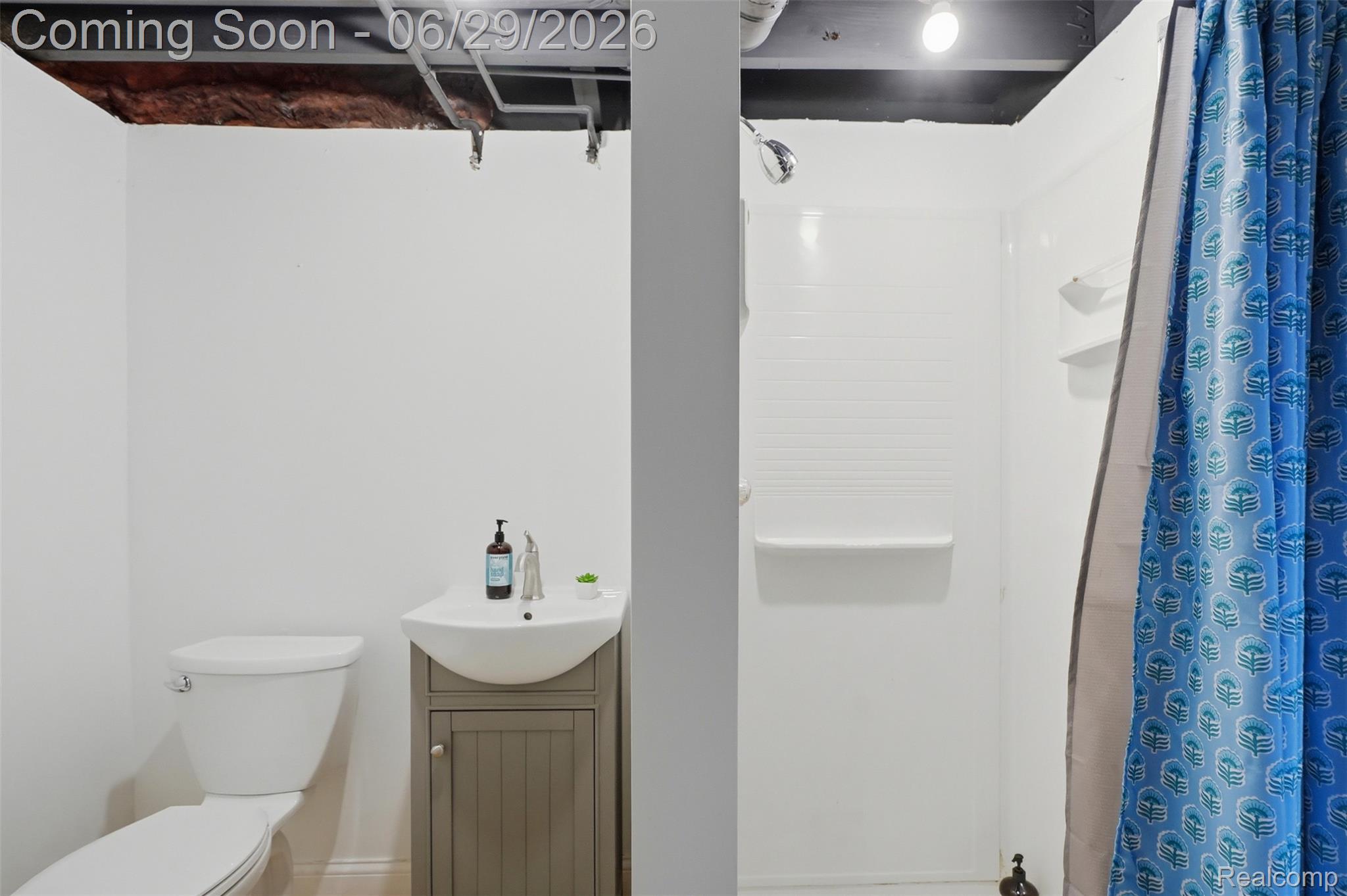 45179 Rudgate Road Canton, MI 48188 - Photo 27 of 48 Compact bathroom featuring a white toilet, a modern vanity with a curved basin, and a shower stall with white paneling