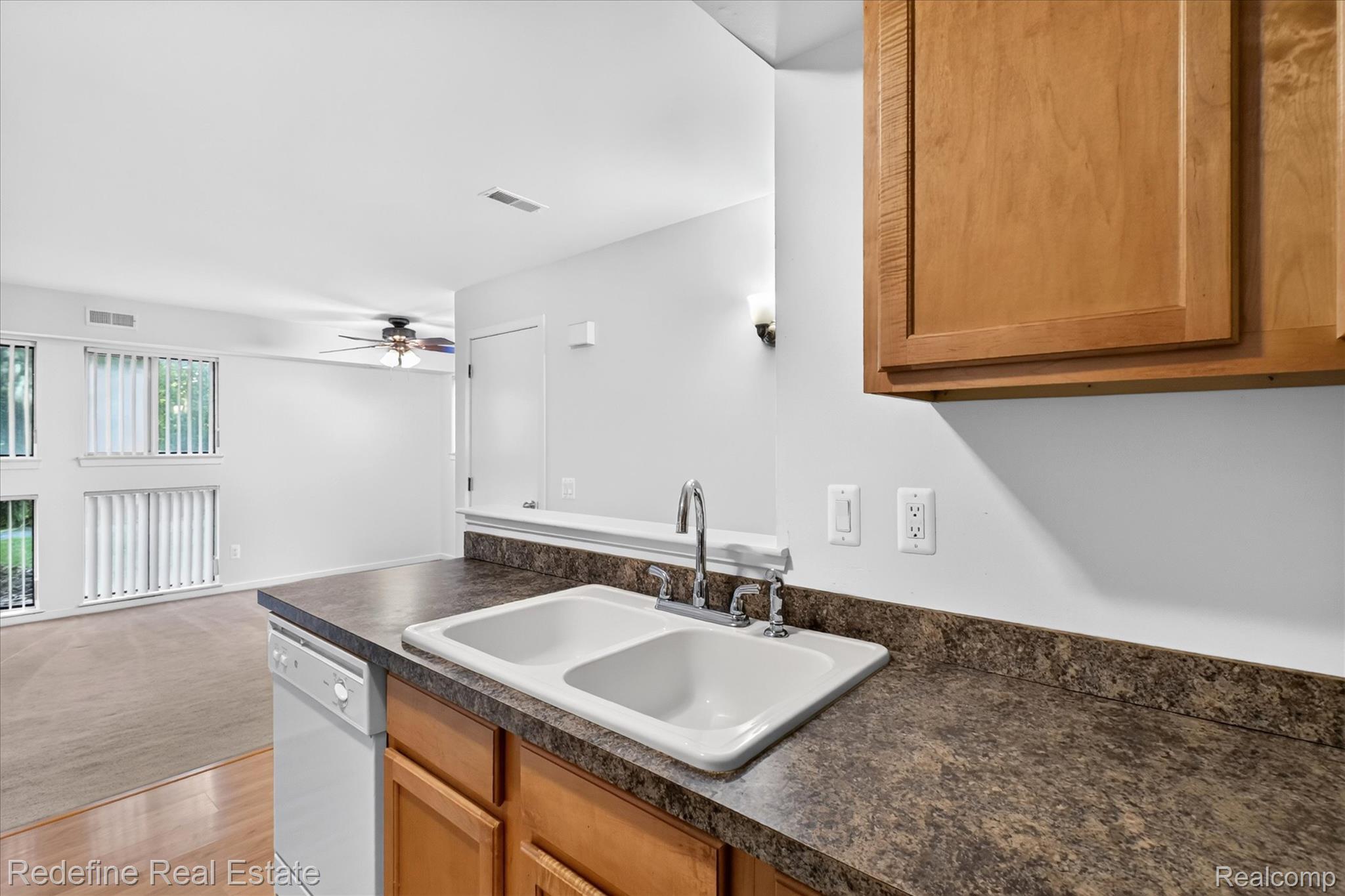 27971 Rollcrest Road, Unit 9 Farmington, MI 48334 - Photo 11 of 25 Kitchen with a double basin sink, chrome faucet, and wood-finish cabinetry