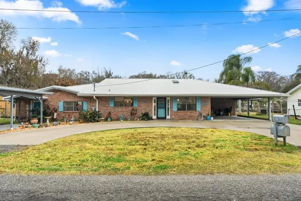 a front view of house with swimming pool and green space