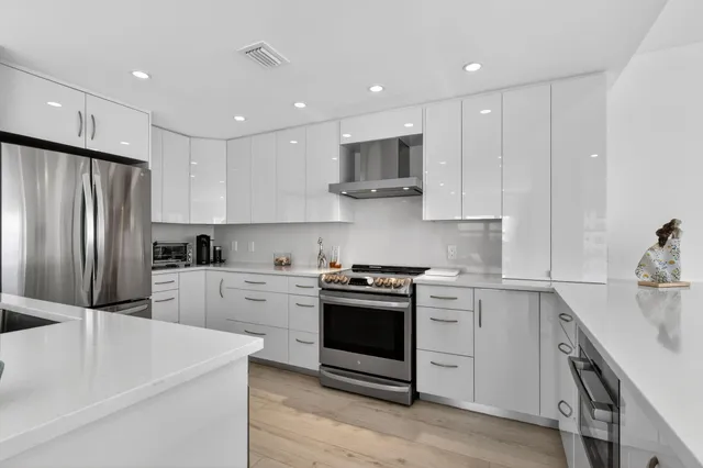 a kitchen with stainless steel appliances granite countertop a sink and stove