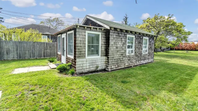 a view of a house with a small yard and wooden fence