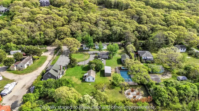 an aerial view of residential houses with outdoor space and trees