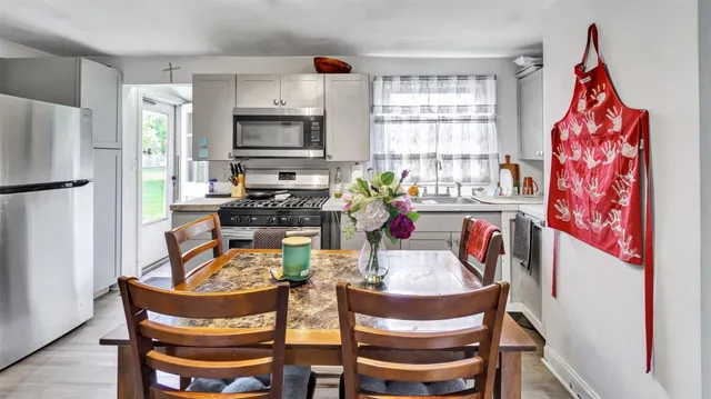 a dining room with furniture a window and stainless steel appliances