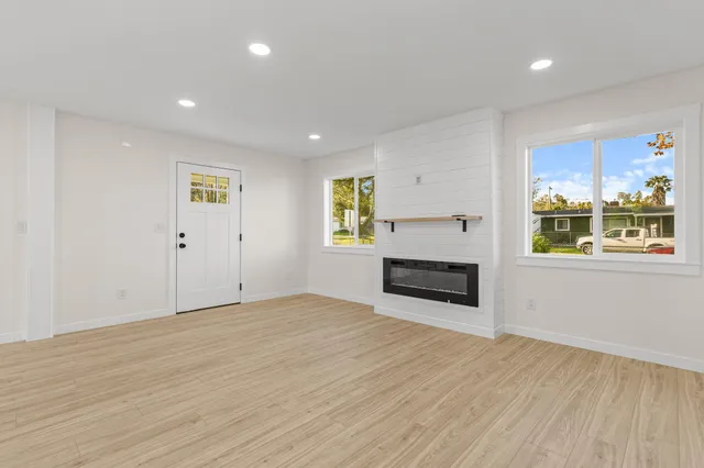 a view of empty room with wooden floor and window