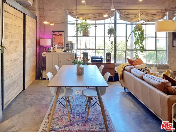 a living room with furniture a large window with kitchen view