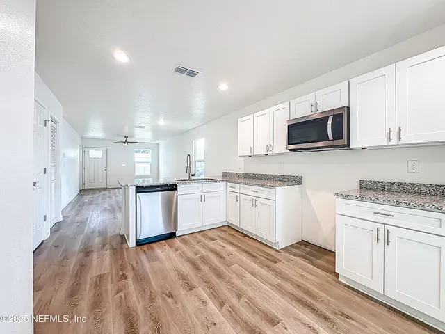 a kitchen with granite countertop white cabinets and white appliances