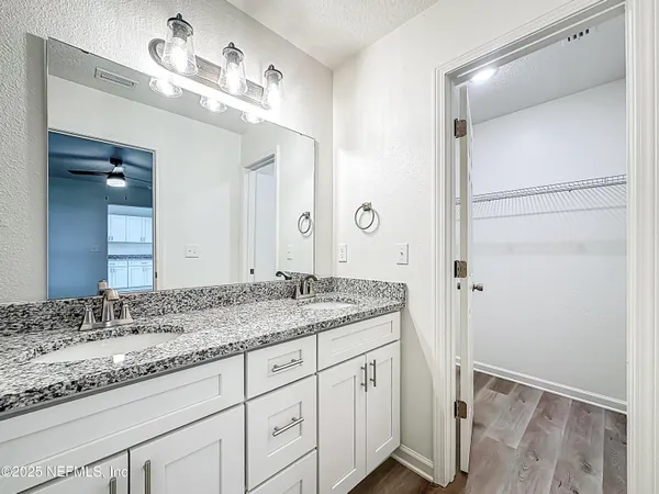 a bathroom with a granite countertop sink and a mirror