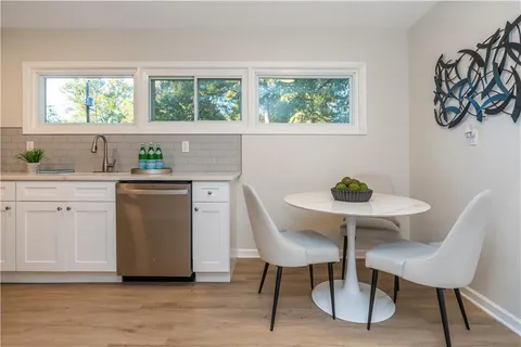 a kitchen with stainless steel appliances a dining table chair and a window