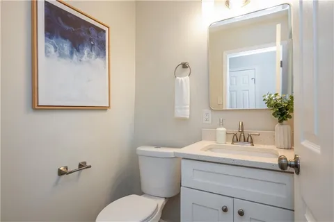 a bathroom with a toilet a sink and mirror