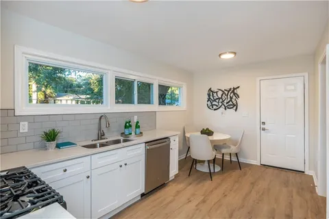 a kitchen with a sink and wooden floor