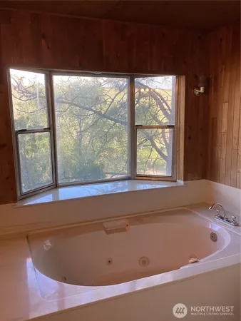 a bath tub sitting in a bathroom next to a window