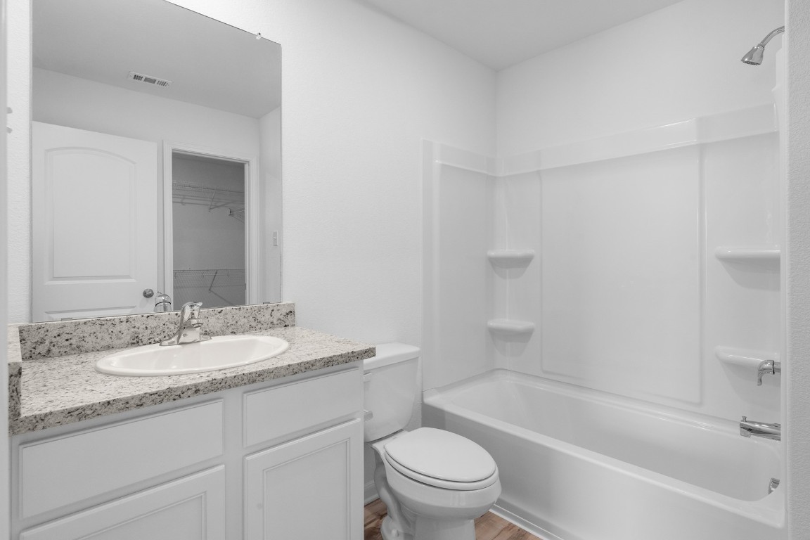 330 Low Pasture Trail Maxwell, TX 78656 - Photo 9 of 11 a bathroom with a granite countertop sink a toilet and bathtub