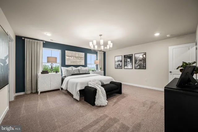a spacious bedroom with a bed a dresser and a chandelier