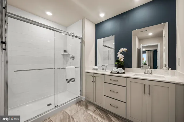a bathroom with a double vanity sink mirror and shower
