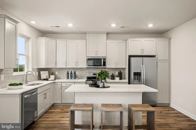 a kitchen with a sink stainless steel appliances and white cabinets