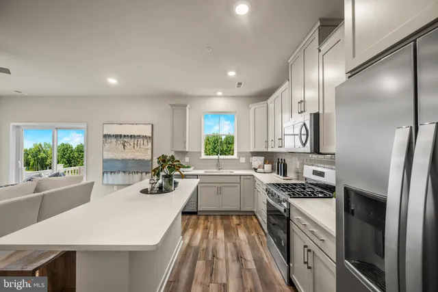 a kitchen with sink a stove and chairs