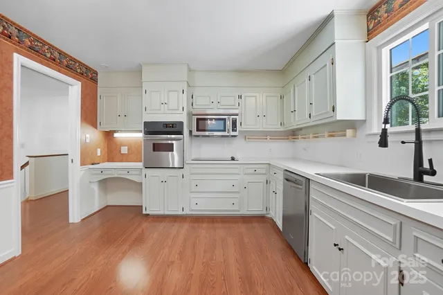 a kitchen with stainless steel appliances granite countertop a sink and a refrigerator