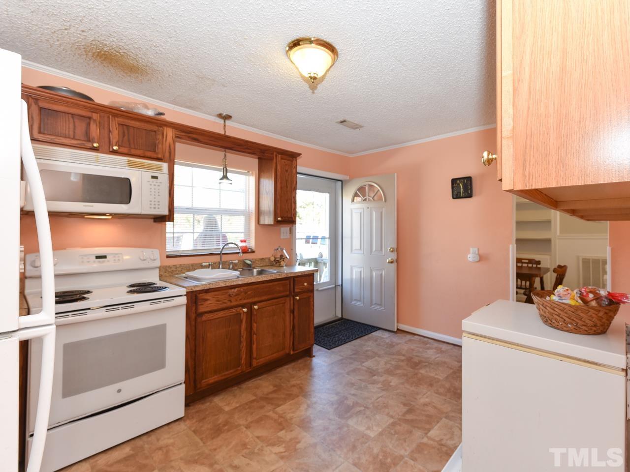 203 Smith Drive Garner, NC 27529 - Photo 2 of 13 a kitchen with a stove oven and a refrigerator