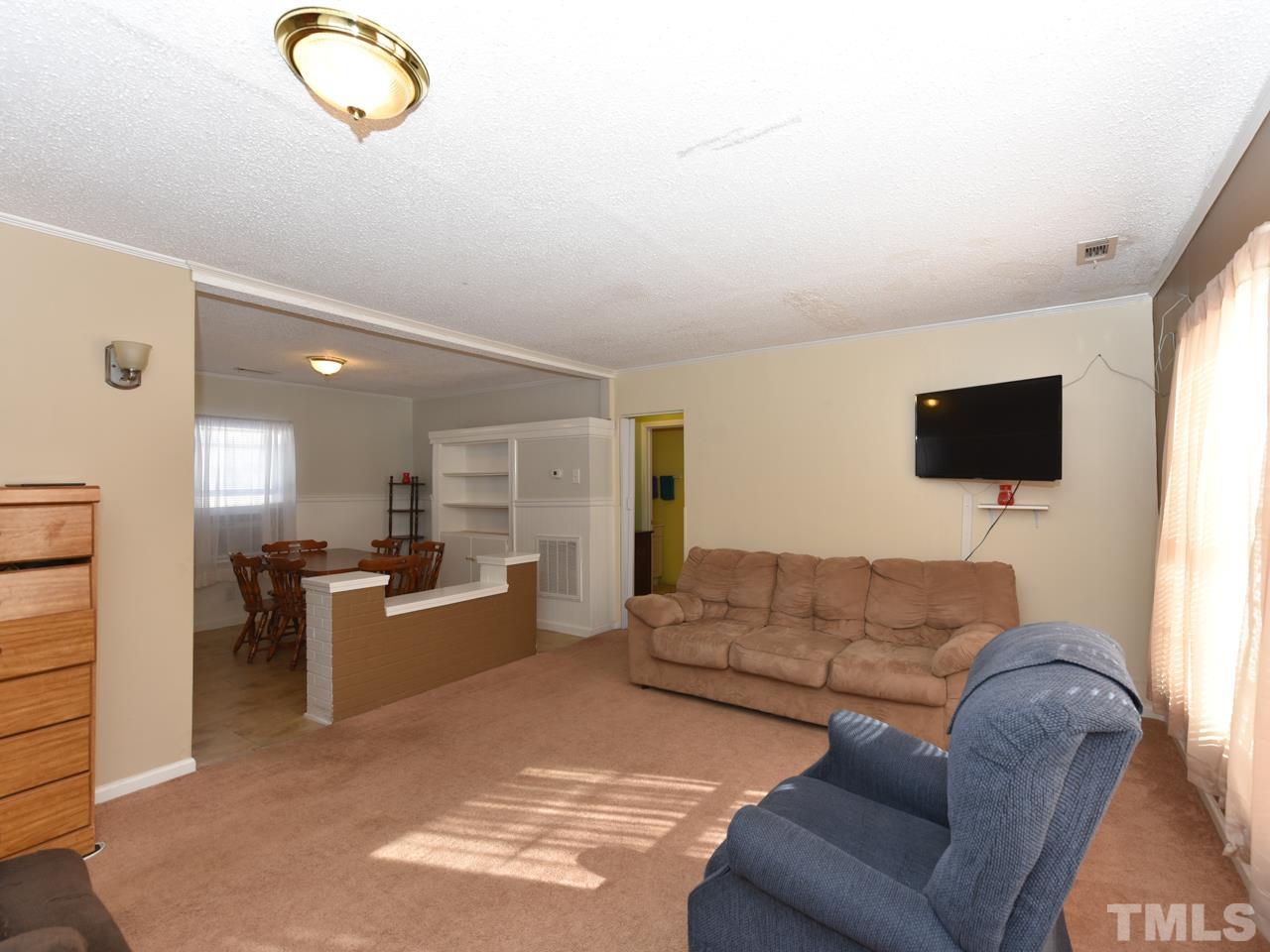 203 Smith Drive Garner, NC 27529 - Photo 10 of 13 a living room with furniture and a flat screen tv