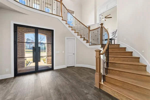 a view of entryway with wooden floor and front door