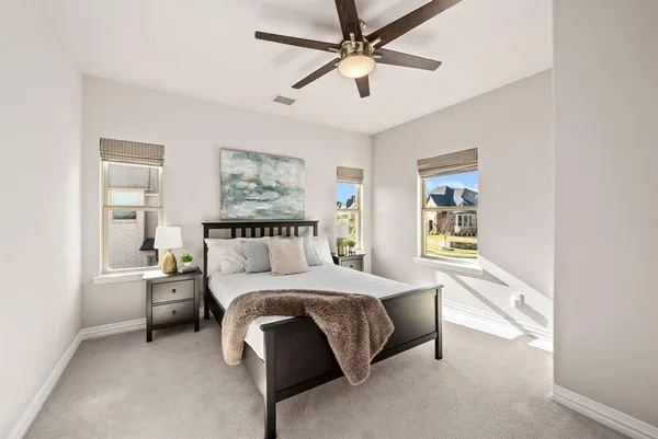 a spacious bedroom with a bed and ceiling fan