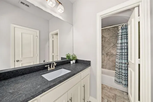 a bathroom with a granite countertop sink and a mirror