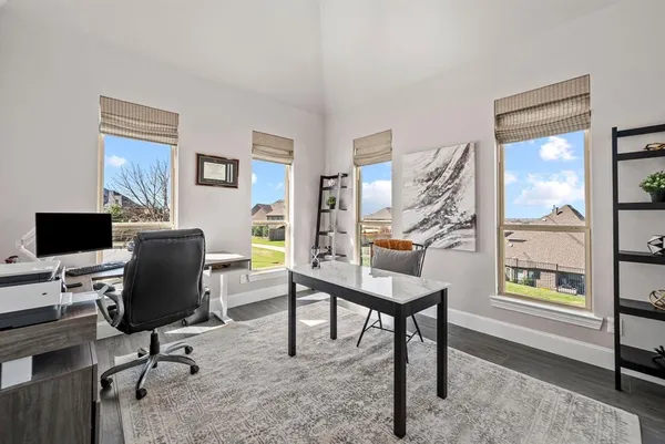 a view of a workspace with furniture and a window