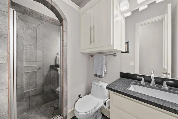 a bathroom with a granite countertop sink toilet a mirror and shower