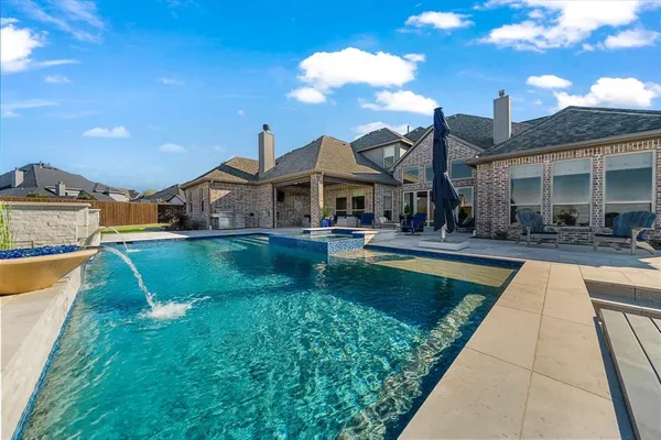 a swimming pool view with a seating space and a garden view